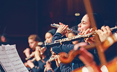 Student playing flute in orchestra