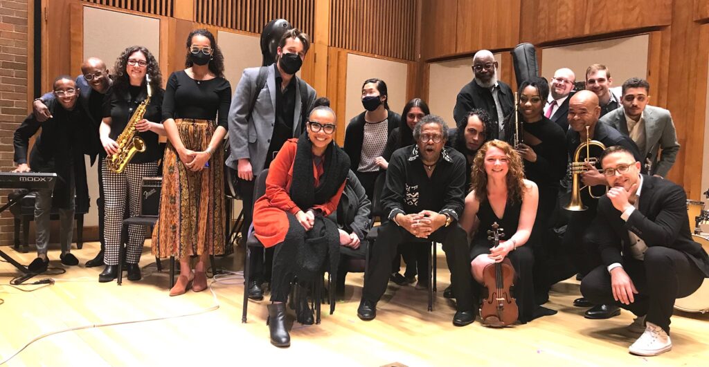 A photo of the members of Imagine Orchestra grouped together on the stage of Pickman Hall